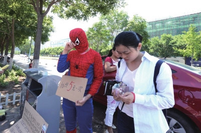 母亲街头扮蜘蛛侠为儿筹钱.jpg